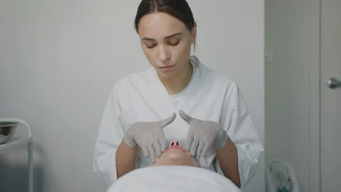 Esthetician massaging face, applying moisturizing cream Stock Footage 126342819
