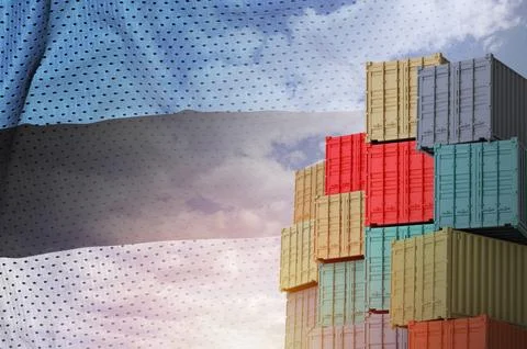 Estonia flag and big stack of shipping cargo containers in docks with sky Foto stock