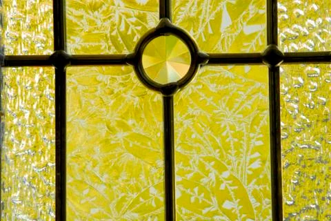 Etched glass window backlit with bright yellow autumn color shinning through Stock Photos
