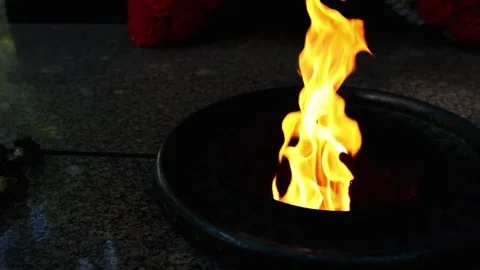 Eternal fire burns at dusk Stock Footage 79940293