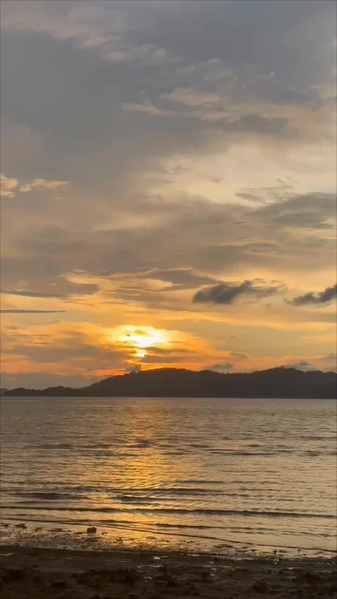 The ethereal light of the setting sun, a glowing ember sinking behind the seren Stock Footage 321379799