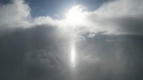 Ethereal sunlight breaking through clouds, camera pans upward revealing sky Video stock 320396698