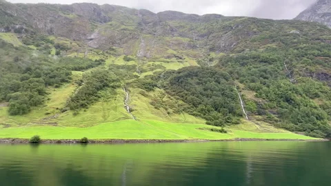 An ethereal view of rolling, cloud-covered mountains mirrored on tranquil waters Stock Footage 313951242