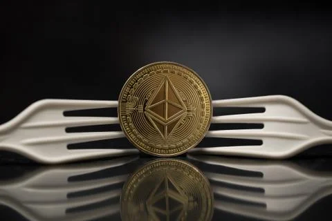 Ethereum Classic next to Two Plastic Forks turned on Backside Stock Photos
