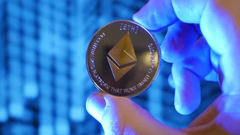 Ethereum coin held in hand between fingers Stock Footage 160985815