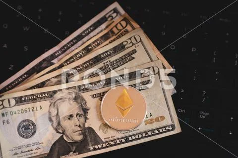 Ethereum Cryptocurrency Coin Token on US Currency and Computer Keyboard Stock Photos
