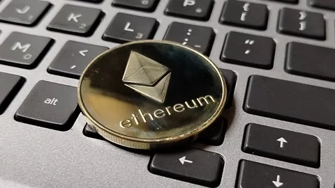 Ethereum token resting on a computer keyboard, illustrating blockchain networks, Stock Footage 340398453