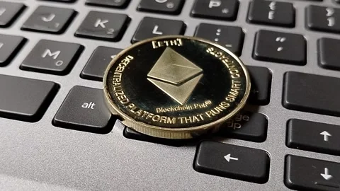 Ethereum token resting on a computer keyboard, illustrating blockchain networks, Stock Footage 340398456