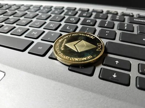Ethereum token resting on a computer keyboard, illustrating blockchain networks, Stock-Fotos