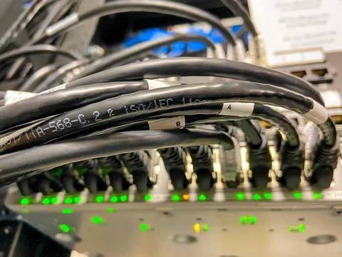 Ethernet cables connected to network equipment with green lights in data center Stock Photos