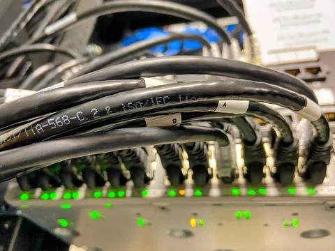 Ethernet cables connected to network equipment with green lights in data c... Stock Photos