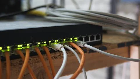 Ethernet cables connected to a network switch with blinking green lights sh.. Stock Photos