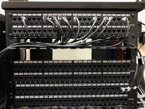 Ethernet patch panels in communication room with cables connected to the ports Stock Photos