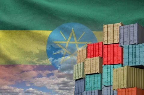 Ethiopia flag and big stack of shipping cargo containers in docks with sky Foto stock