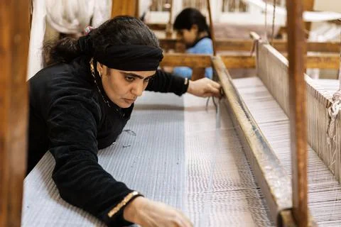 Ethnic female working with threads during weaving Stock Photos