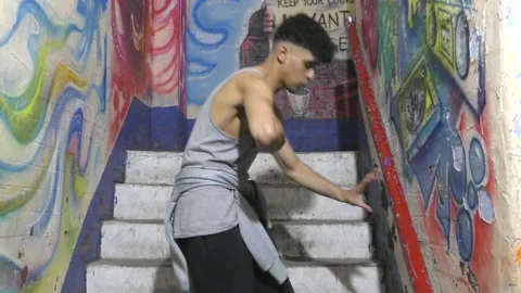 Ethnic young man dancing solo near graffiti. Stock Footage 153030840