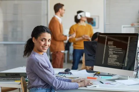 Ethnic Young Woman Programming Software in Office Stockfoto's
