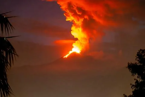 Etna eruption seen from distant foreground trees 스톡 사진