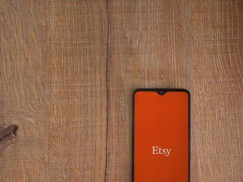 Etsy app launch screen on smartphone on wooden background Stock Photos