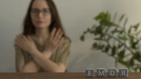 Etters EMDR  on stone cubes, in background woman practicing butterfly hug. Stock Footage 277992724