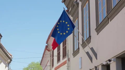 EU and Romanian flags hanging on building facade in Vilnius old town Stock Footage 334719064