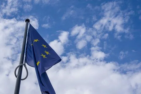 EU flag flying in front of cloudy blue sky Stock Photos