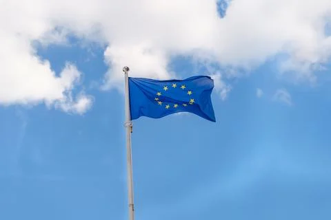 EU flag waving on blue sky background with clouds Stock Photos