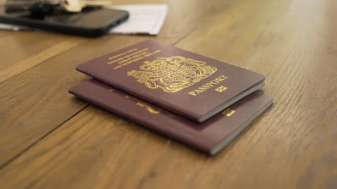 EU passports thrown gently down on desk top. Stock Footage 111777409
