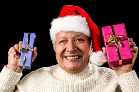 Euphoric old man with two presents and santa hat Stock Photos