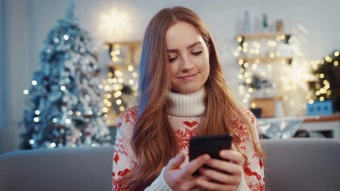 Euphoric red-haired woman using smartphone holding tight enjoying moments of Stock Footage 120416343