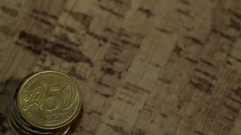 A EUR 10 note falls next to a pile of coins Stock Footage 84225383