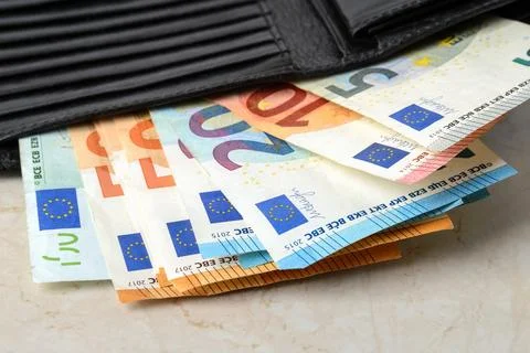 Euro banknotes of different face value in a black leather wallet close-up. Stock Photos