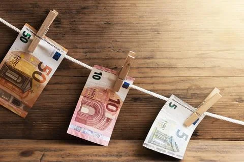 Euro banknotes of different value are drying on a white rope, held by cloth.. 写真素材