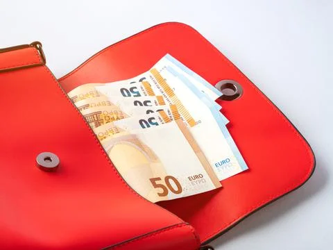 Euro banknotes inside open red female bag on gray background Foto stock
