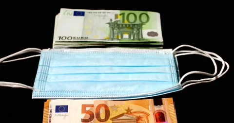 Euro banknotes piled up next to Face masks. Cost of masks and protection Stock Footage 176154020