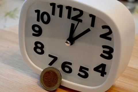 Euro coin next to clock time is money concept Fotos Stock