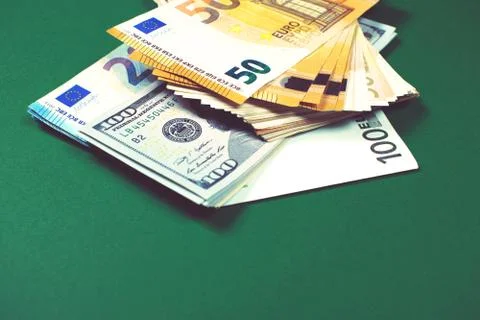 Euro notes and dollar bills on green background. Stock Photos