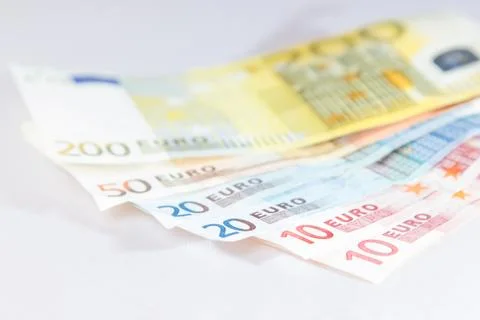Euro notes lying on other notes with white background Stock Photos