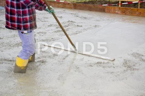 Europe, Germany, Rhineland-Palatinate, Man smoothing concrete for foundation of Stock Photos