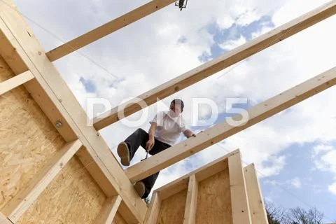 Europe, Germany, Rhineland Palatinate, Man standing on roof beam Stock Photos