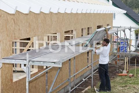 Europe, Germany, Rhineland Palatinate, Young man assembling scaffold Stock Photos