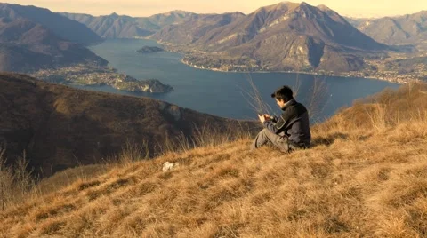 Europe guy sends messages with your smartphone in the mountains Stock Footage 59695485