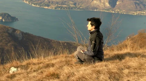 European boy meditates in front of a splendid panorama Stock Footage 59585433