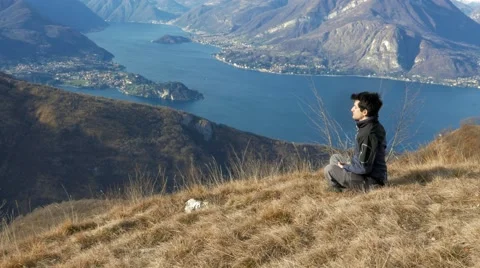 European boy meditating in the mountains Stock Footage 59581901