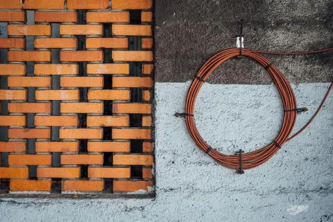European Brick Work Pattern and Electical Cable Coil with Concrete Wall Stock Photos
