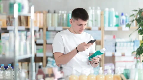 European guy scans the barcode of a mint mouthwash in a pharmacy. Purchase and Stock Footage 311351971