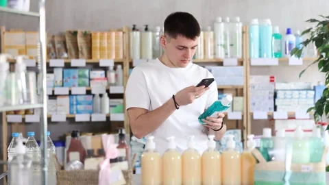 European guy scans the barcode of a mint mouthwash in a pharmacy. Purchase and Stock Footage 321721297