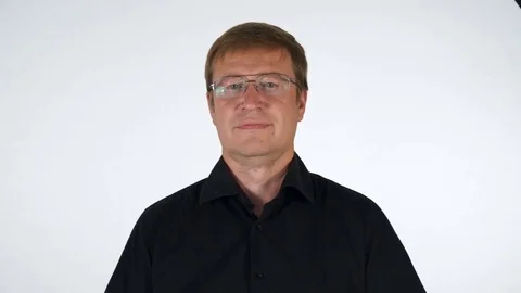 A European man in a black shirt and glasses. He is pleased, confident, shows Stock Footage