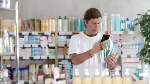 European scans the barcode on the packaging of toothbrushes on a mobile and pays Stock Footage 320445727