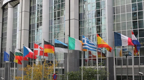 European Union countries flags move, reflect on European Parliament building Stock Footage